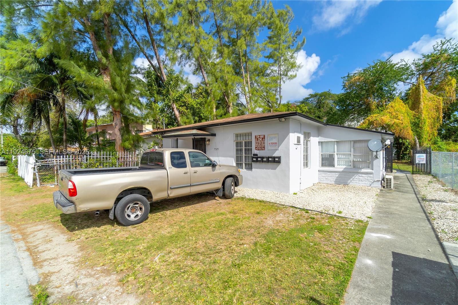 A tan pickup truck is parked in the front yard of a single-story white house — 7525 NE Miami Ct, Miami FL 33138, MIAMI, FL