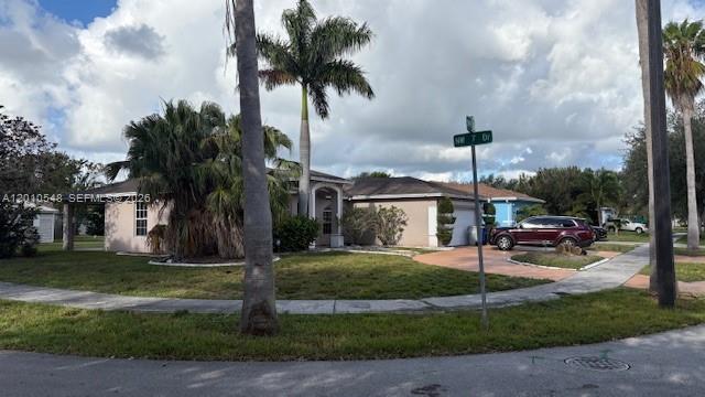 A single-story house with a palm tree, lawn, and a parked car in the driveway — 774 NW 16th Pl, Pompano Beach FL 33060, POMPANO BEACH, FL