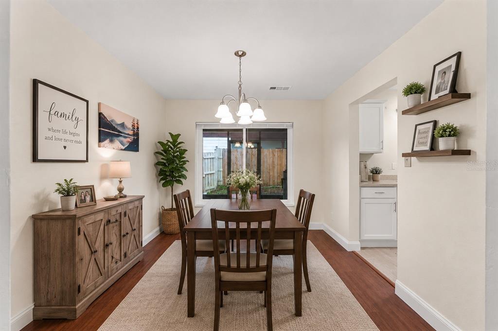 A dining room features a wooden table, chairs, a sideboard, and wall-mounted shelves — 3822 RAVENNA DRIVE, VALRICO, FL