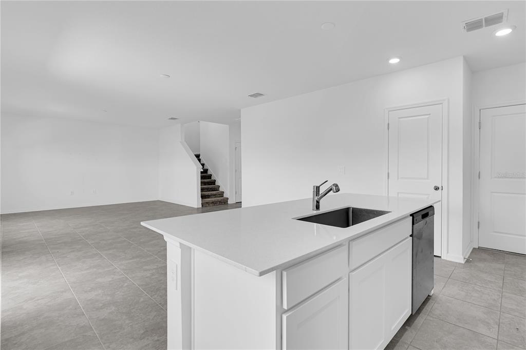 A kitchen island with a sink and dishwasher sits in a room with tiled floors — 1021 WATERFALL BOULEVARD, DAVENPORT, FL