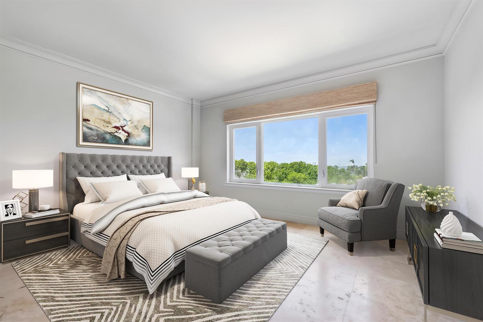 A bedroom features a tufted gray bed, a matching bench, and a large window view — 250 Bradley Place # 606, Palm Beach FL 33480, PALM BEACH, FL