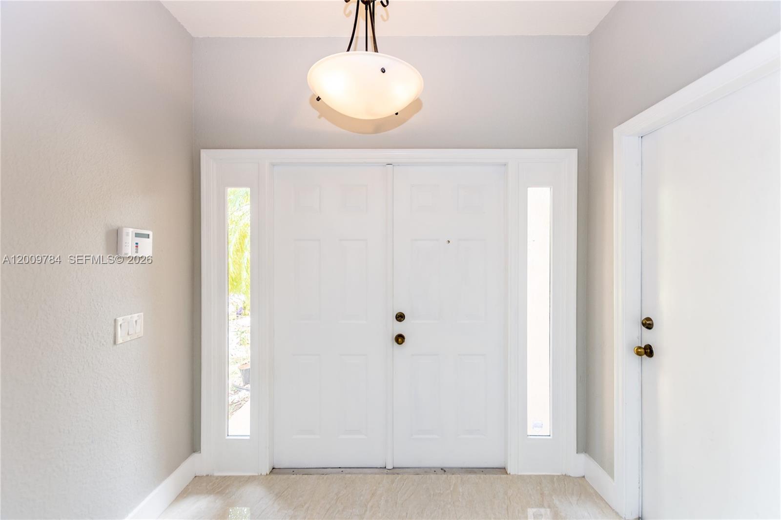 A white double front door with sidelights is centered in a light-colored entryway — 980 Golden Cane Dr, Weston FL 33327, WESTON, FL