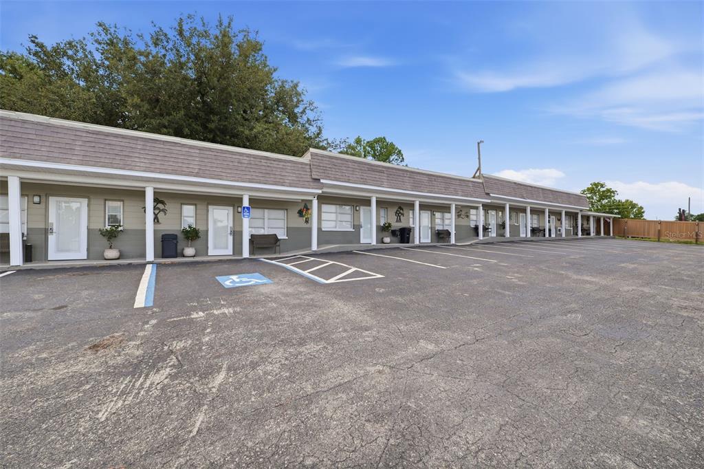 A single-story motel building with a covered walkway and an asphalt parking lot — 8744 GALL BLVD, ZEPHYRHILLS, FL