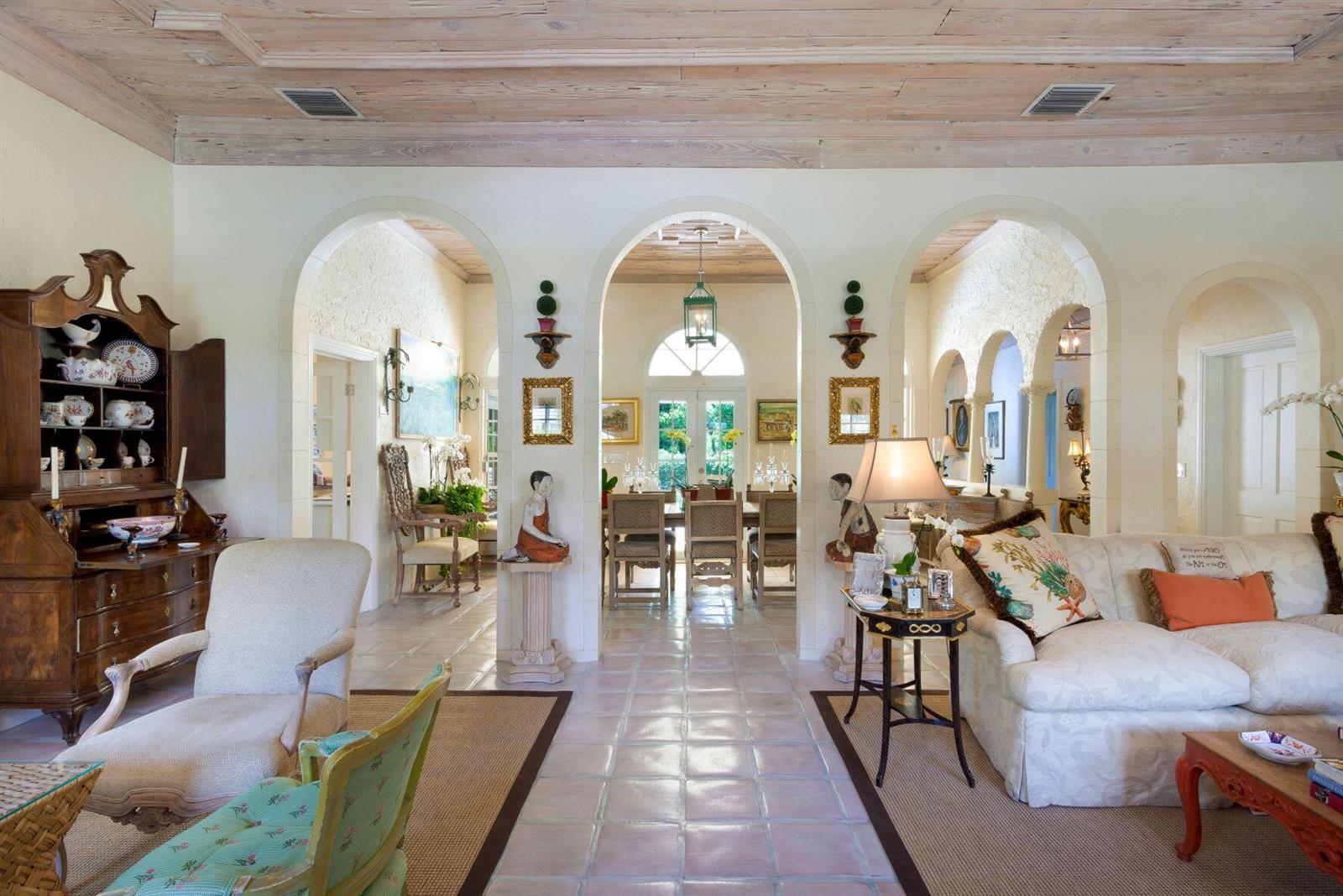 A living room with arched doorways, tile floors, and a wood-paneled ceiling leads to dining — 4210 Washington Road, West Palm Beach FL 33405, WEST PALM BEACH, FL