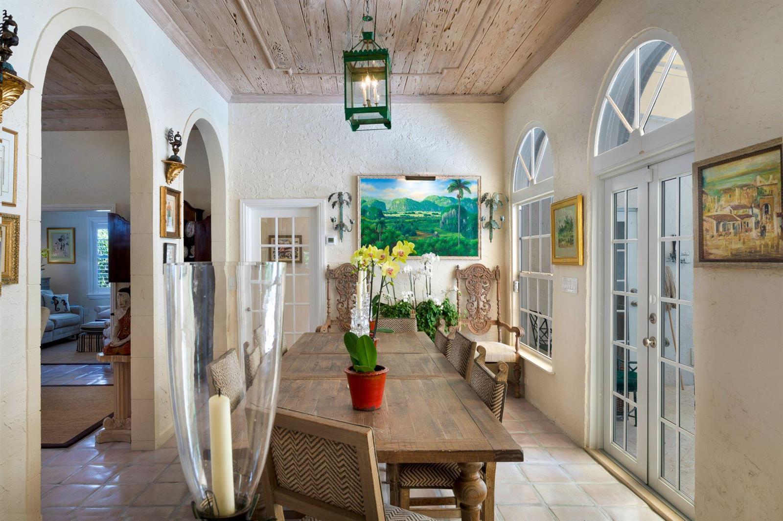 A dining room with a wooden ceiling, arched doorways, tile floors, and a long table — 4210 Washington Road, West Palm Beach FL 33405, WEST PALM BEACH, FL