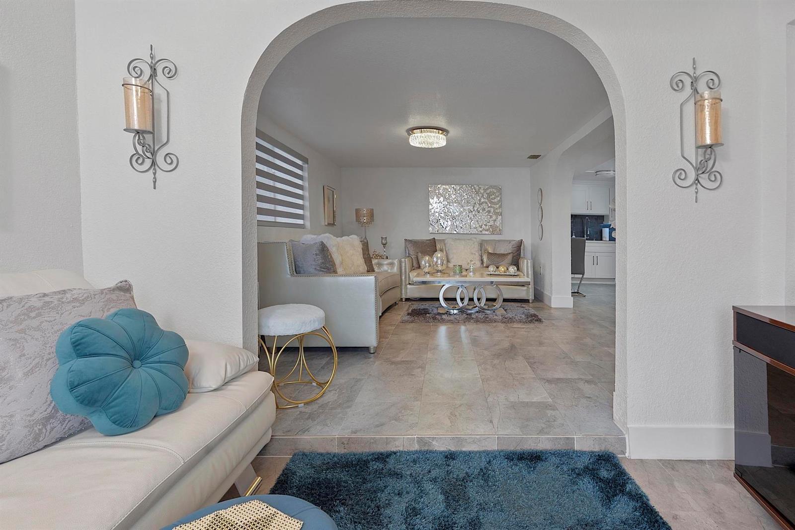 A living room with a sunken seating area, arched entryway, and tile flooring — 3205 W 16th Avenue, Hialeah FL 33012, HIALEAH, FL