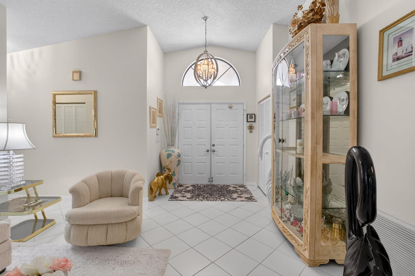 A bright entryway features white tile floors, a glass display cabinet, and a double door — 4643 Sextant Circle, Boynton Beach FL 33436, BOYNTON BEACH, FL