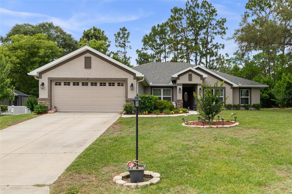 A single-story suburban house with a two-car garage and a landscaped front yard — 2 BALSAM DRIVE, HOMOSASSA, FL
