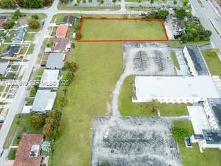 An aerial view shows a rectangular vacant lot outlined in red next to a parking lot — 1855 NW 119th St, Miami FL 33167, MIAMI, FL