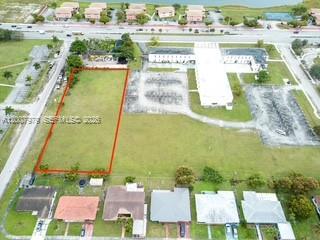 An aerial view shows a rectangular vacant lot outlined in red next to a parking lot — 1855 NW 119th St, Miami FL 33167, MIAMI, FL