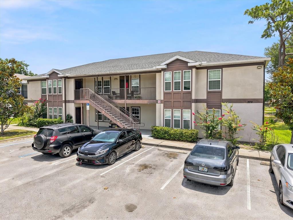 A two-story apartment building with a central staircase and a parking lot in front — 272 HART LANE, KISSIMMEE, FL