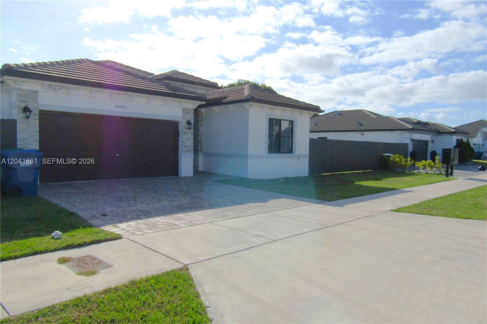 A single-story house with a tiled roof, a paved driveway, and a two-car garage — 16825 SW 109th Pl, Miami FL 33157, MIAMI, FL
