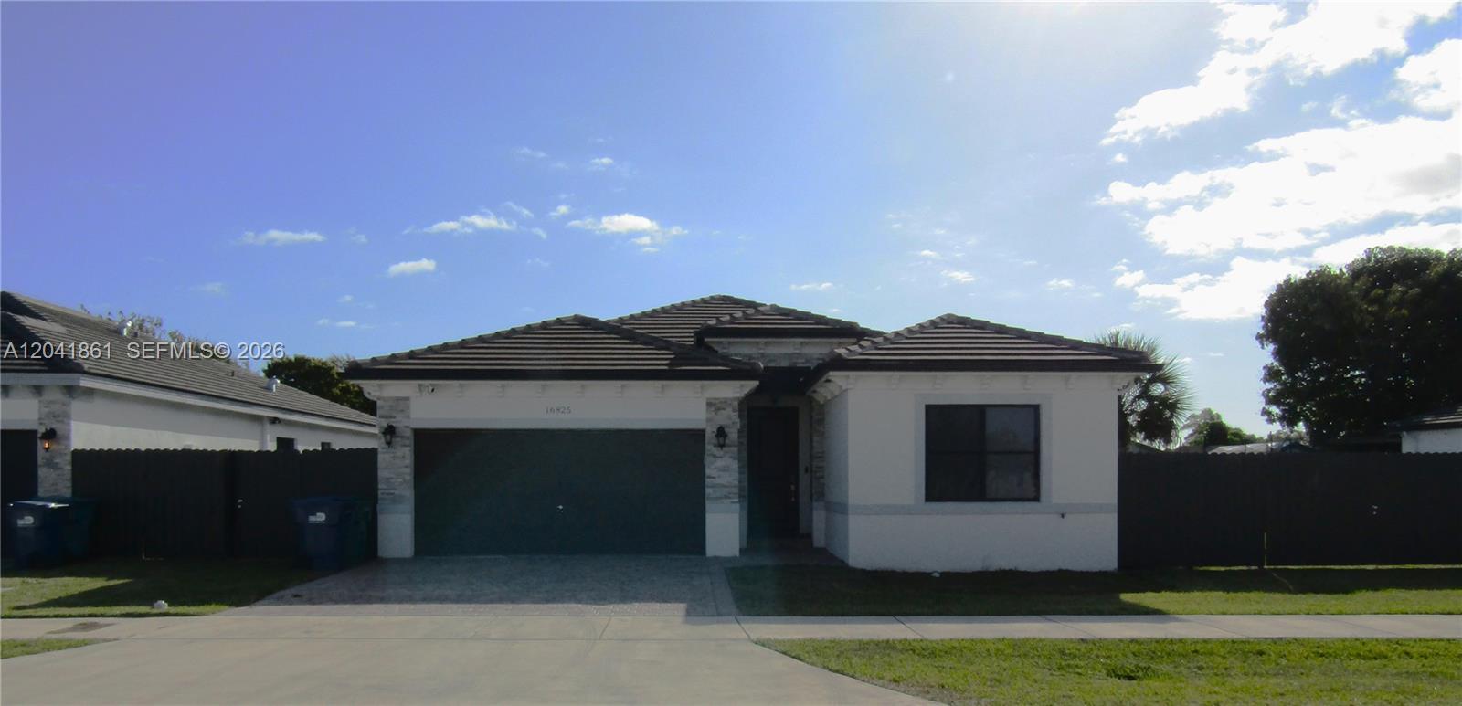 A single-story house features a two-car garage, stone accents, and a dark tiled roof — 16825 SW 109th Pl, Miami FL 33157, MIAMI, FL