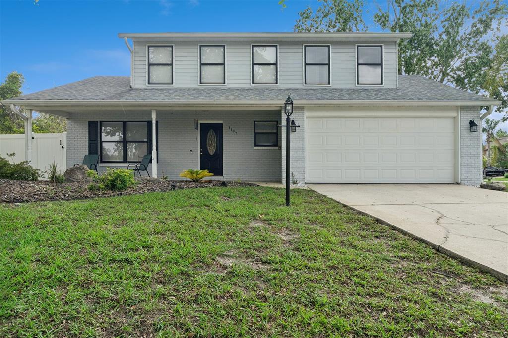 A two-story house with a gray brick lower level, light gray siding, and a garage — 1197 SOUTHFORK COURT, PORT ORANGE, FL