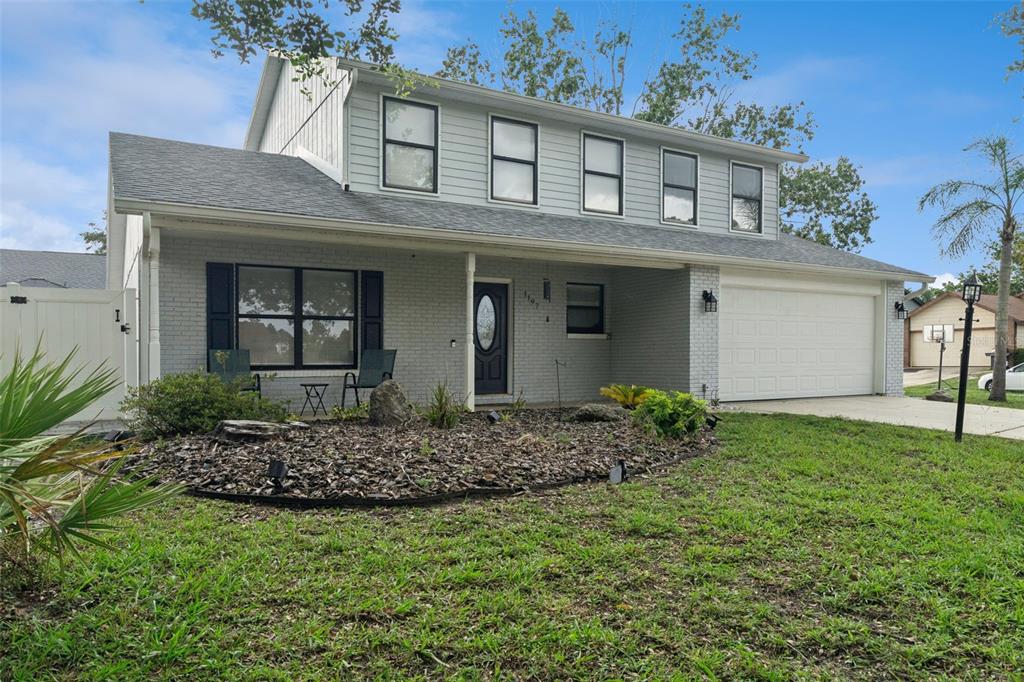A two-story house with light gray siding, a brick facade, and a two-car garage — 1197 SOUTHFORK COURT, PORT ORANGE, FL