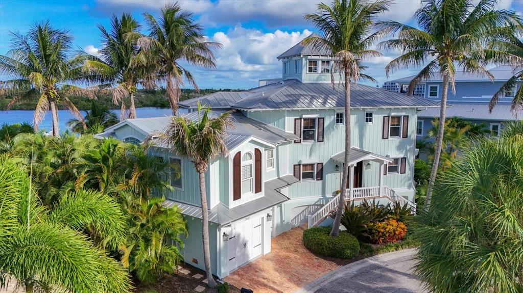 A light green three-story coastal house with a metal roof and palm trees — 13310 ANGLERS WAY, PLACIDA, FL