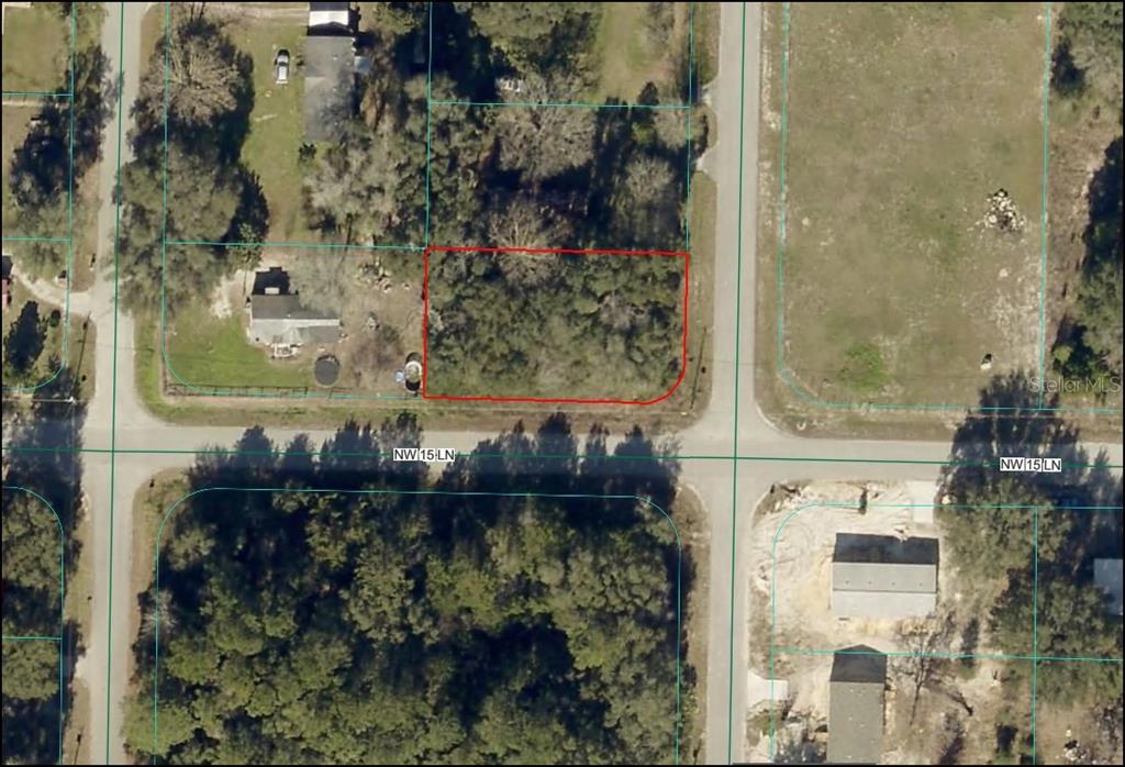 This is an aerial map showing a vacant, wooded rectangular lot outlined in red — NW 15TH LANE, OCALA, FL