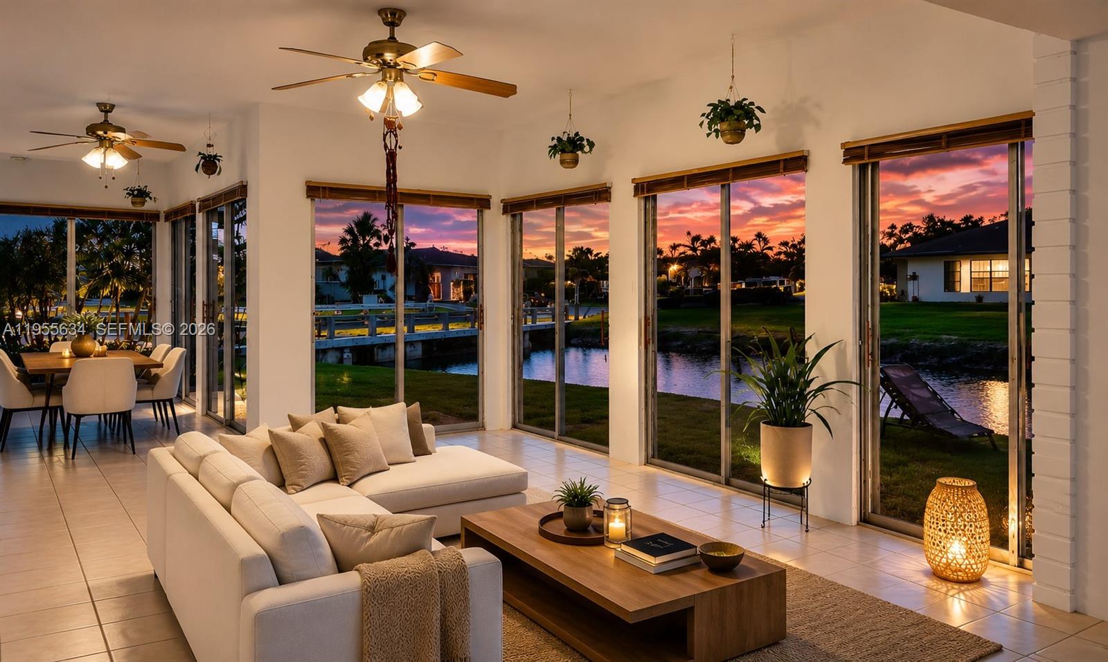 A living room with a white sofa, wooden coffee table, and sliding glass doors overlooking water — 5700 White Hickory Cir, Tamarac FL 33319, TAMARAC, FL
