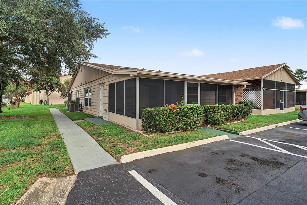 A single-story residential building with a screened-in porch and an adjacent parking lot — 1001 PLANTATION DRIVE UNIT C1, KISSIMMEE, FL