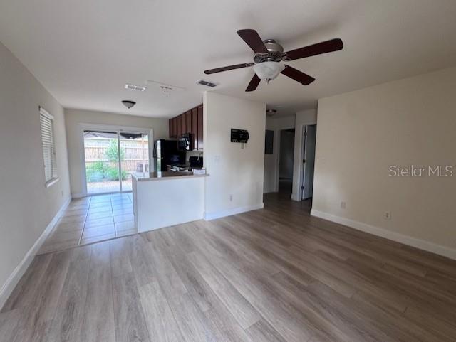 An open-concept living area features light wood-look flooring, a ceiling fan, and a kitchen island — 3152 S BUMBY AVENUE UNIT C3, ORLANDO, FL