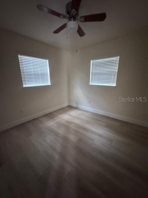 An empty bedroom features light-colored wood-look flooring, cream walls, two windows with blinds, and a ceiling fan — 3152 S BUMBY AVENUE UNIT C3, ORLANDO, FL