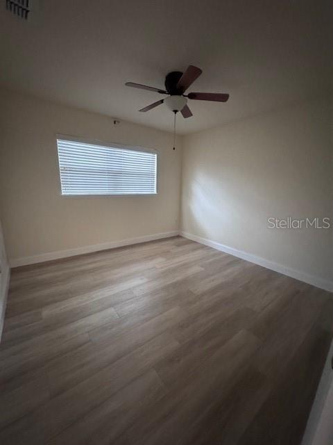 An empty bedroom features light wood-look flooring, off-white walls, a ceiling fan, and window blinds — 3152 S BUMBY AVENUE UNIT C3, ORLANDO, FL