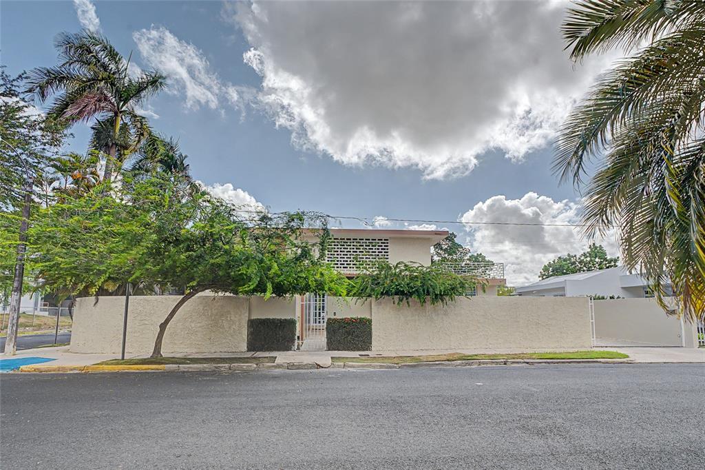 A two-story house with a beige stucco wall and a decorative screen block facade — 901 HARVARD, SAN JUAN, PR
