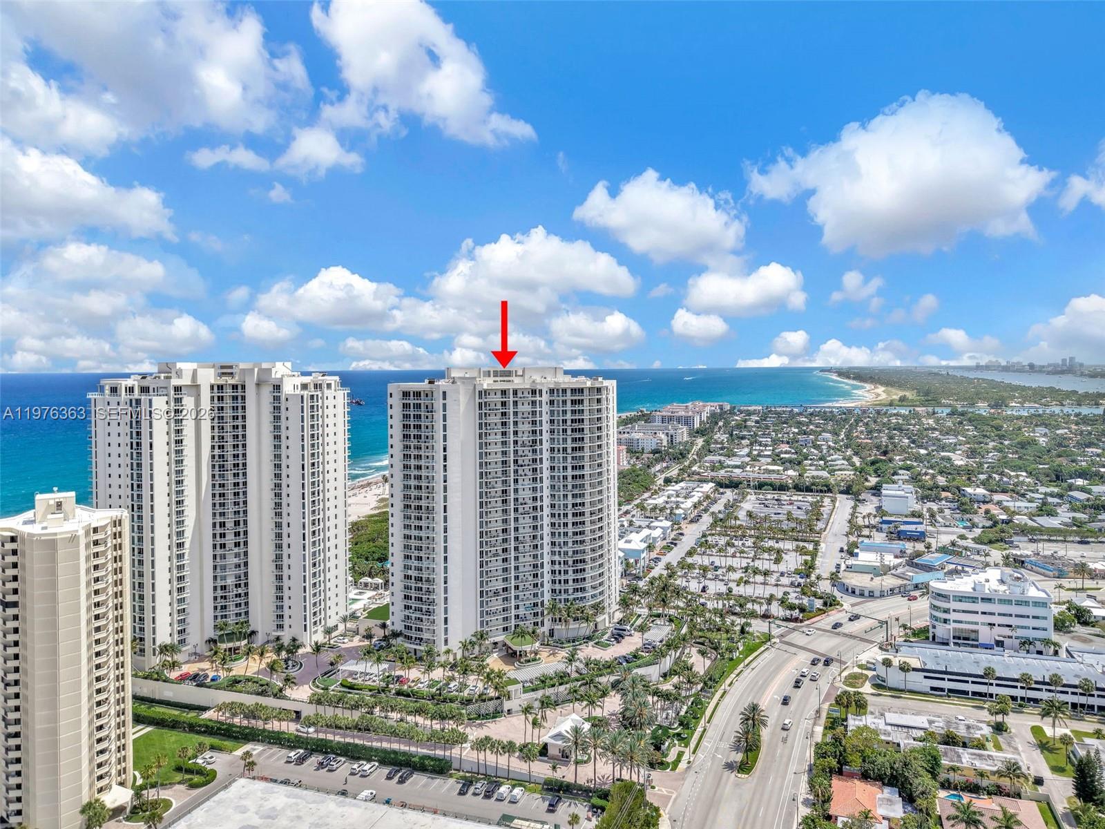 An aerial view shows high-rise residential buildings located along a coastal shoreline — 2700 N Ocean Drive # 902B, Singer Island FL 33404, SINGER ISLAND, FL