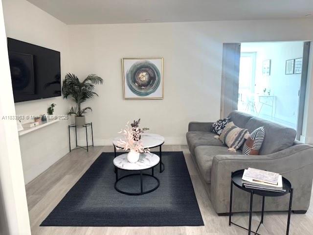 A living room features a grey sofa, a dark rug, and a round coffee table — 19380 NE 26th Ave # 304, Miami FL 33180, MIAMI, FL