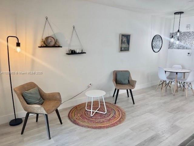 A living and dining area features light wood floors, two chairs, and a small table — 19380 NE 26th Ave # 304, Miami FL 33180, MIAMI, FL