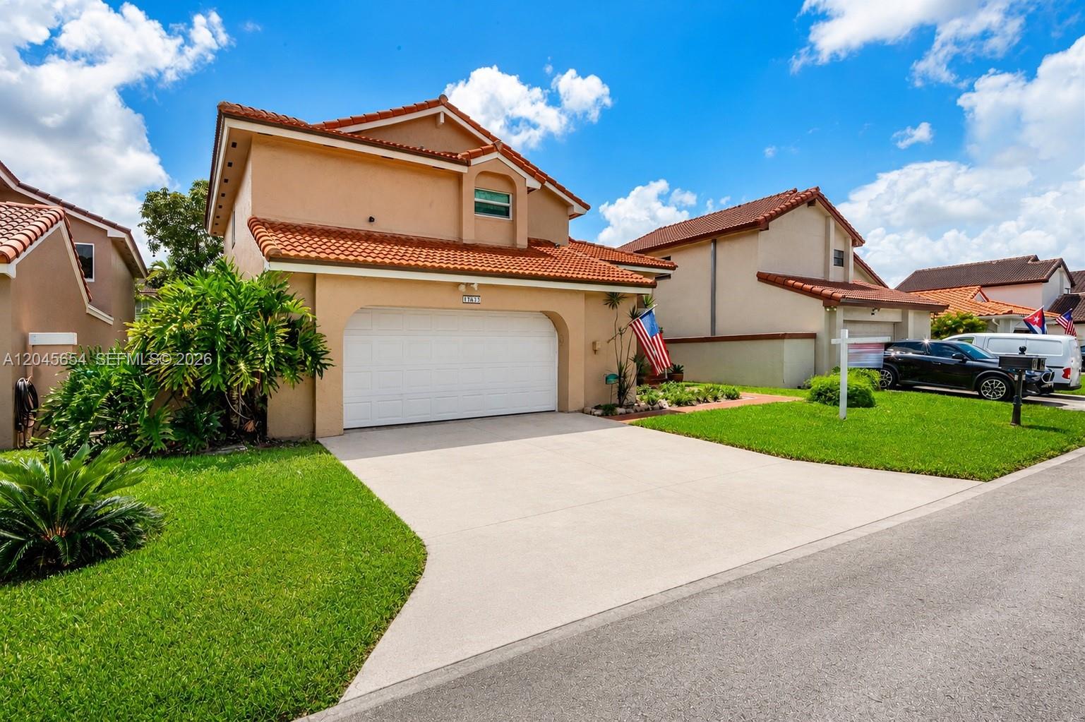 A two-story suburban house with a tan stucco exterior, red tile roof, and garage — 17617 NW 61st Ct N, Hialeah FL 33015, HIALEAH, FL