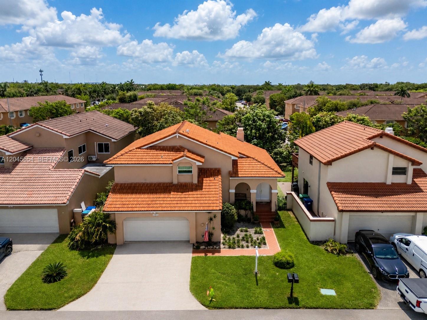 An aerial view shows a two-story suburban house with a tiled roof and attached garage — 17617 NW 61st Ct N, Hialeah FL 33015, HIALEAH, FL