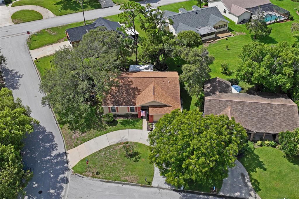 An aerial view of a suburban house with a brown shingled roof and a driveway — 8050 EACON COURT, HUDSON, FL