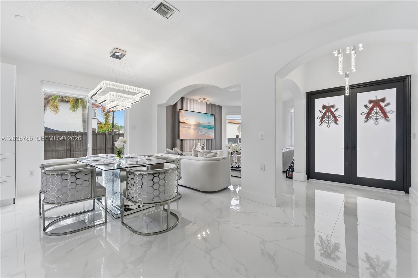 A dining area and living room feature white marble floors, modern lighting, and black doors — 14452 SW 10th St, Miami FL 33184, MIAMI, FL