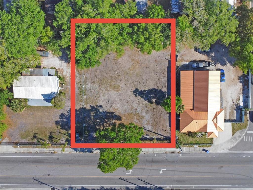 An aerial view shows a rectangular vacant lot outlined in red between two existing buildings — 0 DONEGAN, KISSIMMEE, FL