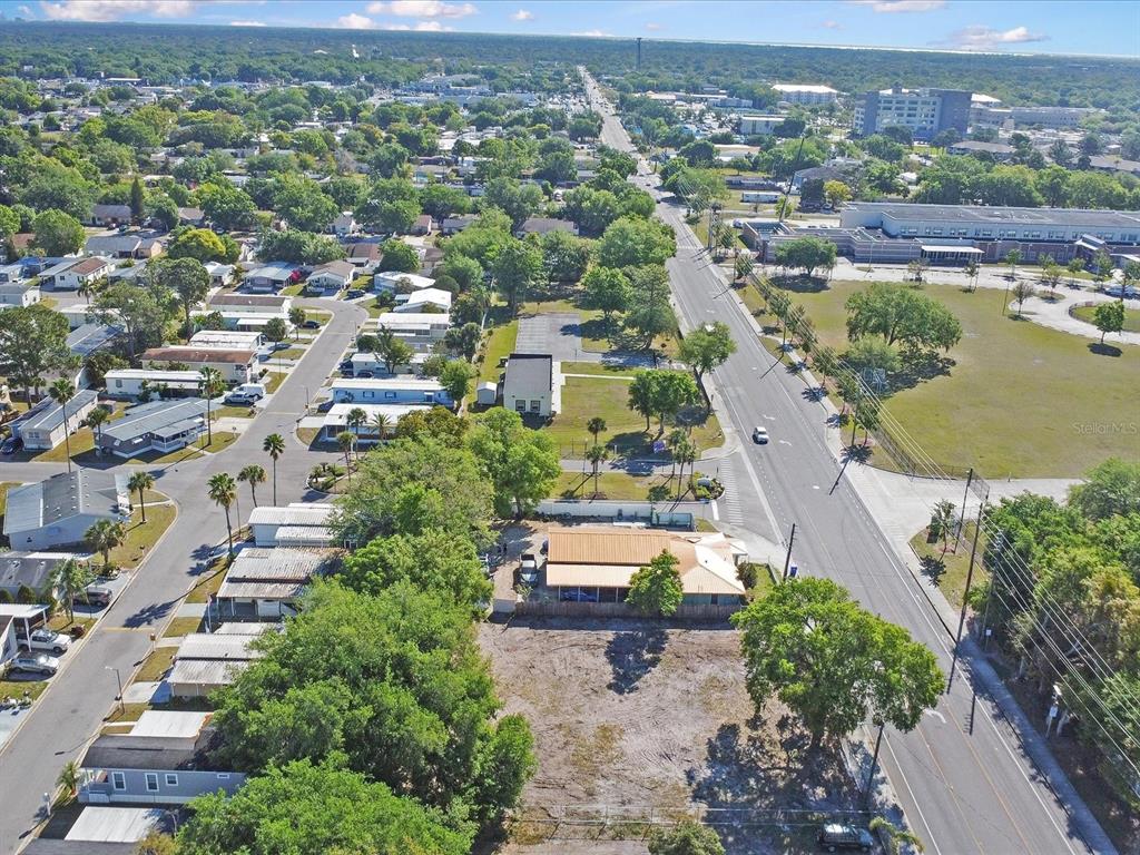 An aerial view shows a residential street with mobile homes, a vacant lot, and a building — 0 DONEGAN, KISSIMMEE, FL