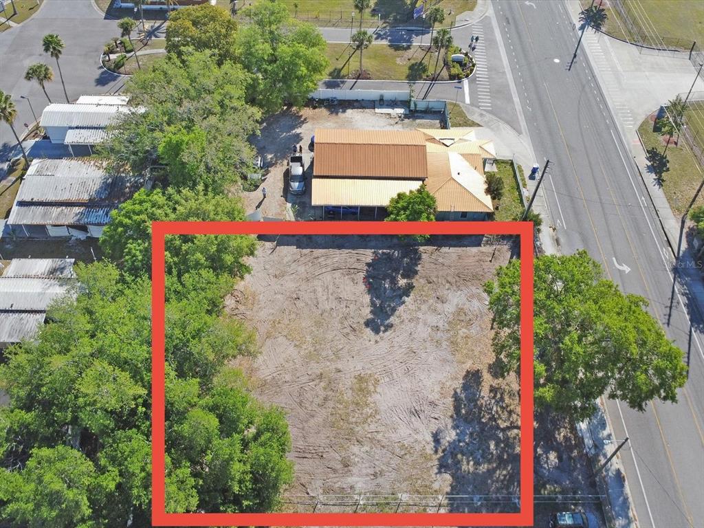 An aerial view shows a cleared, rectangular vacant lot outlined in red next to a building — 0 DONEGAN, KISSIMMEE, FL