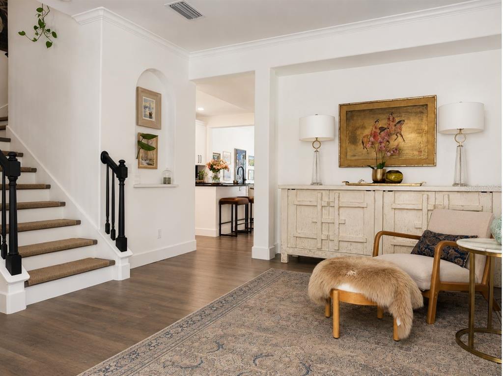 A bright entryway features a staircase, a console table, an armchair, and a view beyond — 1152 LAKE BALDWIN LANE, ORLANDO, FL