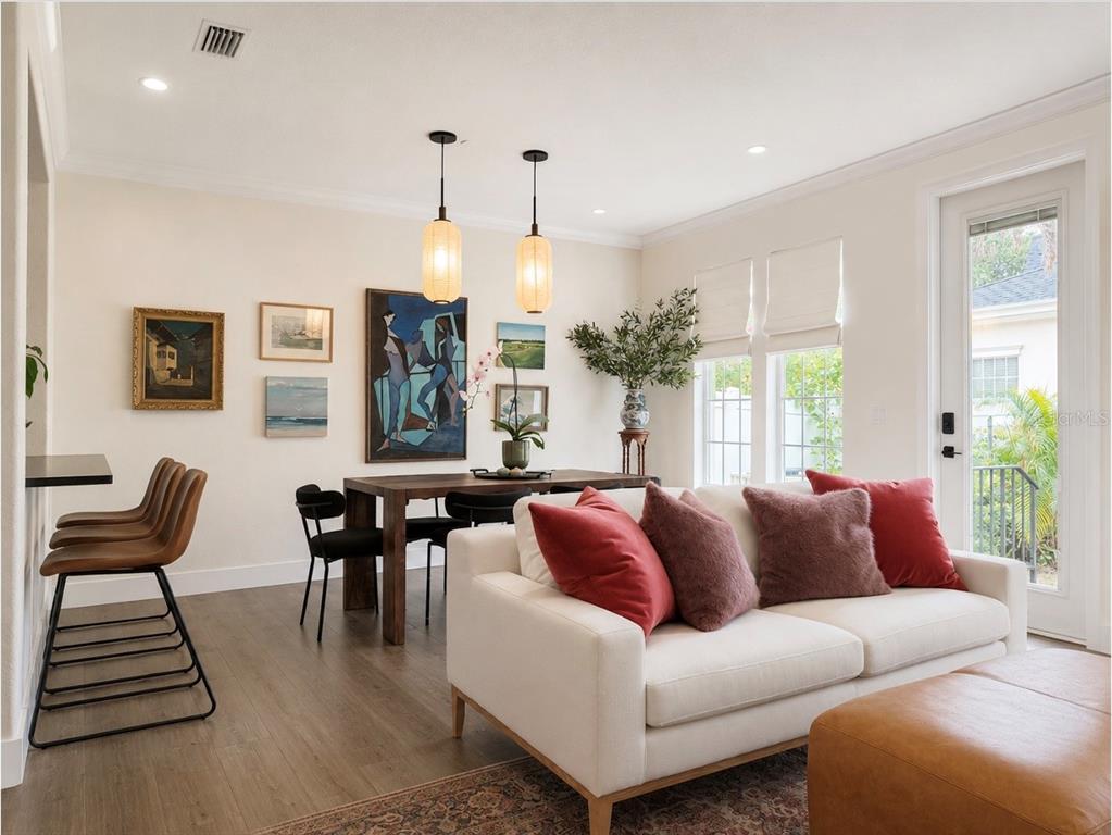 A kitchen features white cabinets, black countertops, stainless steel appliances, and a central island with stools — 1152 LAKE BALDWIN LANE, ORLANDO, FL