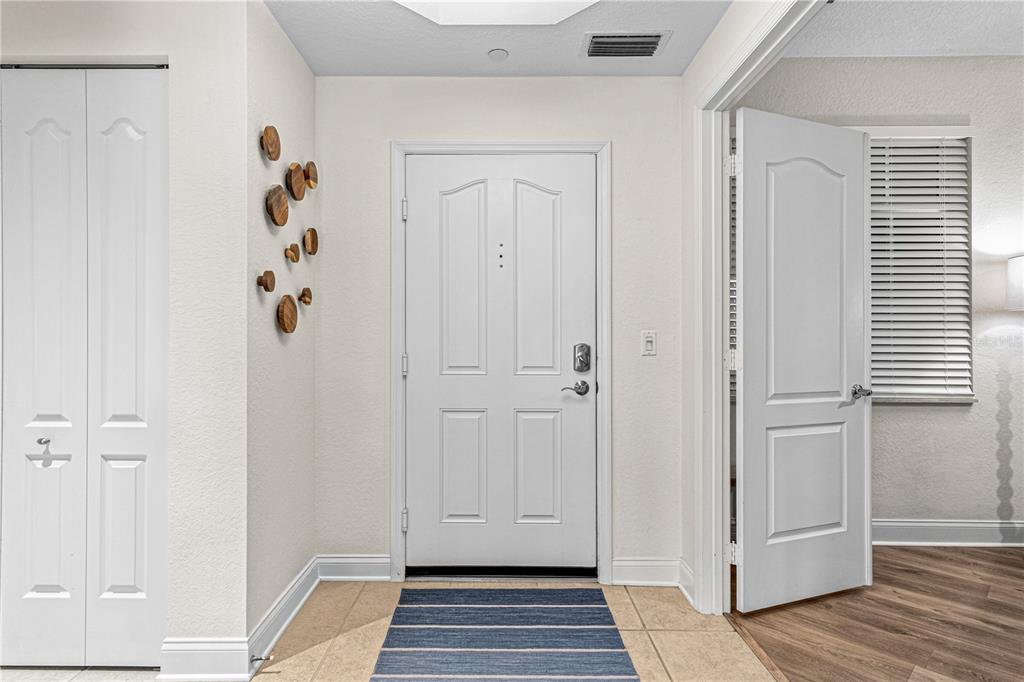 An entryway features a white front door, tiled floor, and decorative wall accents — 263 MINORCA BEACH WAY UNIT 206, NEW SMYRNA BEACH, FL