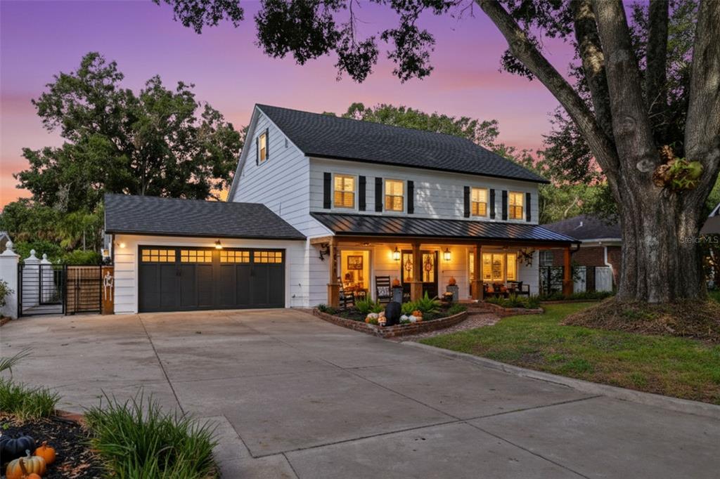 A two-story white house with a dark roof, attached garage, and a front porch — 1511 S SHERIDAN FOREST DRIVE, TAMPA, FL