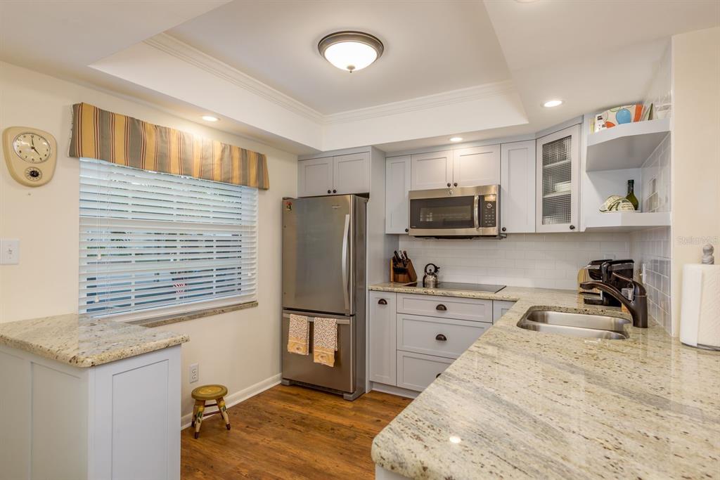 A kitchen with light gray cabinets, stainless steel appliances, and granite countertops — 952 VIRGINIA STREET UNIT 105, DUNEDIN, FL