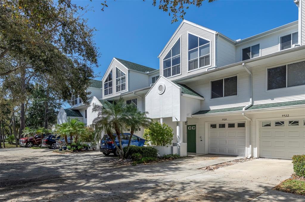 A row of white multi-story townhouses with attached garages and a shared driveway — 9920 INDIAN KEY TRAIL UNIT 29, SEMINOLE, FL