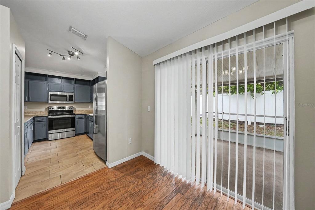 A kitchen with dark blue cabinets and stainless steel appliances opens to a patio area — 4803 DUNQUIN PLACE, TAMPA, FL