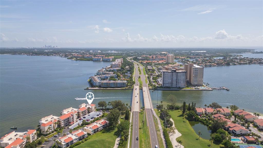 An aerial view shows a waterfront condominium complex next to a bridge and highway — 5736 PUERTA DEL SOL BOULEVARD S UNIT 254, ST PETERSBURG, FL