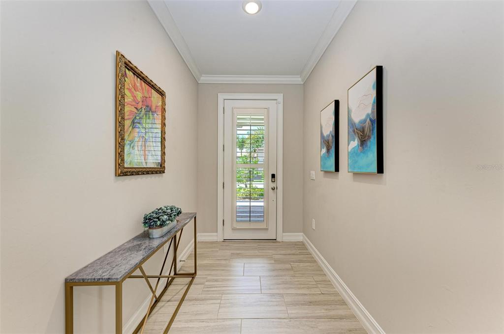 A bright entryway features light tile flooring, a console table, and wall art — 244 VILLORESI BOULEVARD, NOKOMIS, FL