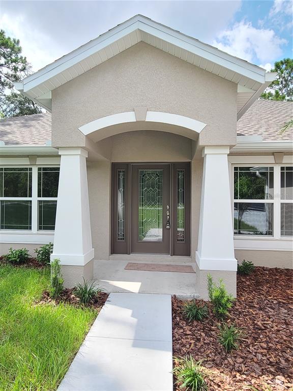 A bright, open-concept dining area features tile flooring, a chandelier, and an arched kitchen entryway — 11367 LATCHWOOD AVENUE, WEEKI WACHEE, FL