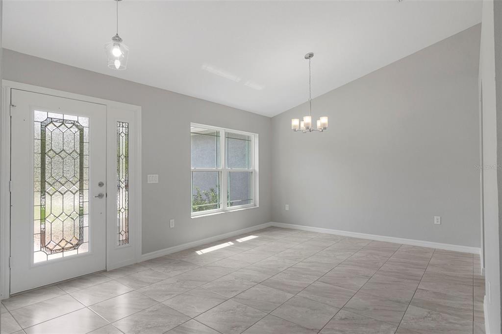 A kitchen features dark wood cabinets, granite countertops, a stainless steel sink, and sliding doors — 11367 LATCHWOOD AVENUE, WEEKI WACHEE, FL
