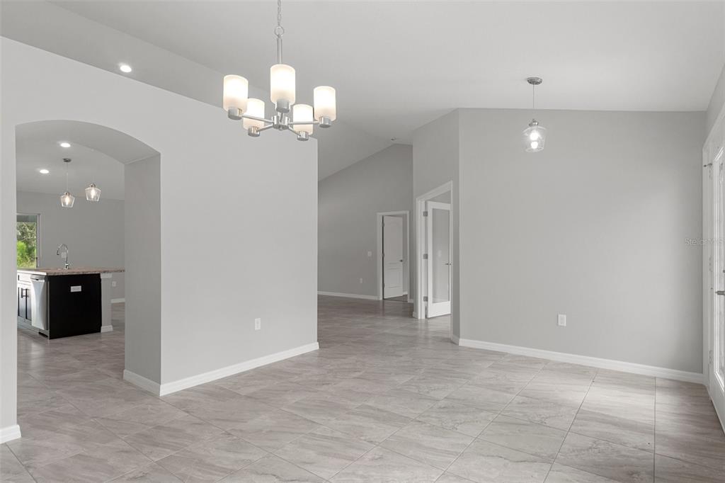 A kitchen features dark wood cabinets, granite countertops, stainless steel appliances, and a central island — 11367 LATCHWOOD AVENUE, WEEKI WACHEE, FL