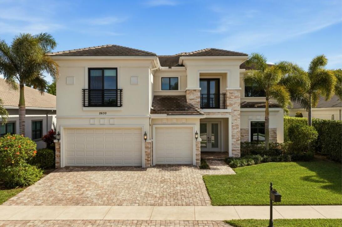 A bright living room features a curved wooden staircase, high ceilings, and large windows — 2630 NW 69th Street, Boca Raton FL 33496, BOCA RATON, FL